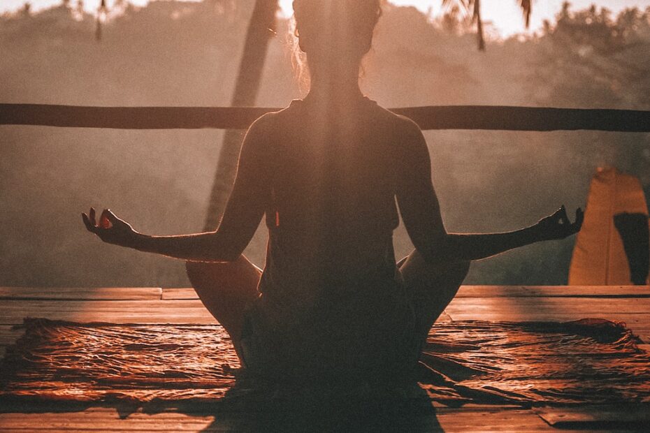 woman doing yoga meditation on brown parquet flooring